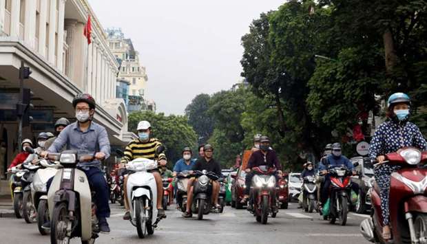 Residents wear protective face masks as they ride motorbikes on a street after the government eased the nationwide lockdown during the coronavirus disease outbreak in Hanoi, Vietnam.