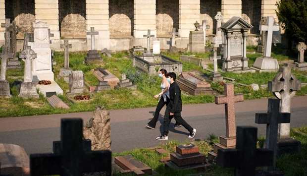 People wearing protective masks exercise in Brompton Cemetery, amid the coronavirus disease (Covid-19) outbreak, in London