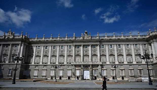 A woman walks her dog in front of the Royal Palace in Madrid amid a national lockdown to fight the spread of the coronavirus, Covid-19 disease
