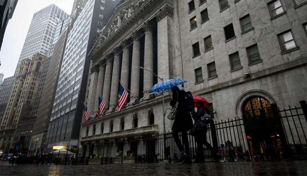 People pass the New York Stock Exchange