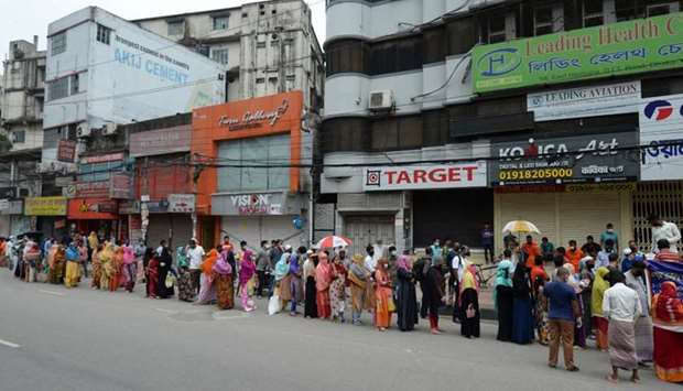 People queue to collect subsidised food items during a government-imposed nationwide lockdown as a preventive measure against the Covid-19 coronavirus, in Dhaka