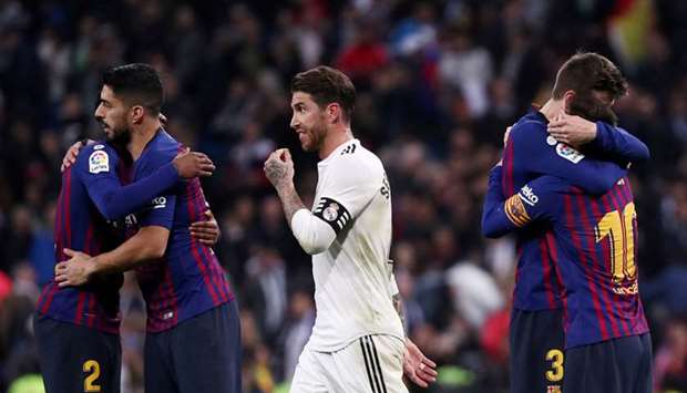 In this March 2, 2019, picture, Barcelona players celebrate their victory as Real Madridu2019s Sergio Ramos (centre) walks off after their La Liga match at Santiago Bernabeu in Madrid, Spain. (Reuters)