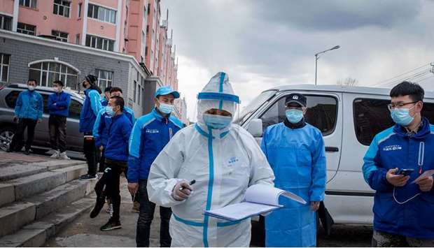 A medical worker checking notes in front of food delivery employees, in queue to have their nucleic acid test as part of Covid-19 pandemic measures, at a health services centre in Suifenhe in Chinau2019s northeastern Heilongjiang province yesterday.