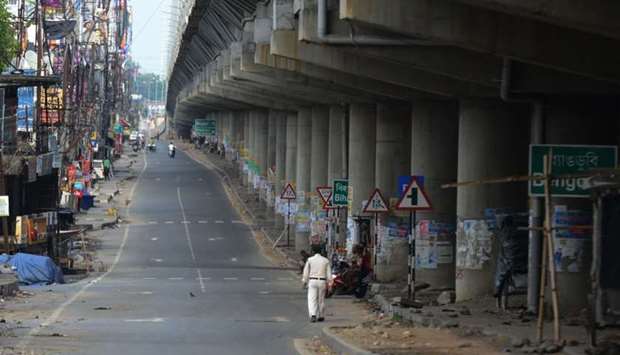 A man walks along a deserted road during a government-imposed nationwide lockdown as a preventive measure against the COVID-19, at Bagdogra on the outskirts of Siliguri, India
