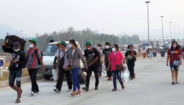 Migrant workers from Myanmar are seen on the border as they try to go back their home country due to coronavirus disease (Covid-19) outbreak, at Mae Sot, Thailand in this March 25 picture. The lethality and contagiousness of the coronavirus has prompted a return to hard national borders and other barriers.