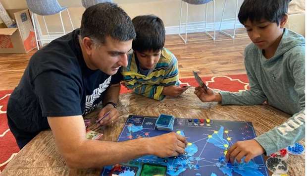 NO CHILDu2019S PLAY: Dr Amit Gohil plays the board game Pandemic with two of his three children, sons Shaan, centre, and Akaal.