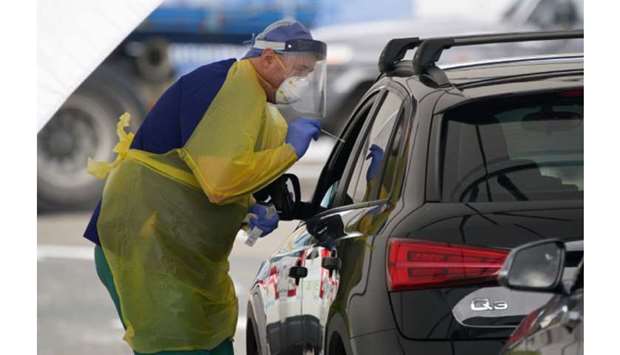 A medical personnel administers tests for the coronavirus disease at the Bondi Beach drive-through testing centre in Sydney, Australia.