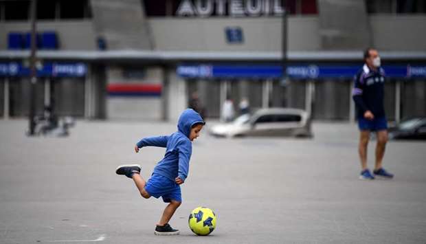 A child plays football in front of the Parc des Princes stadium in Paris yesterday. (AFP)