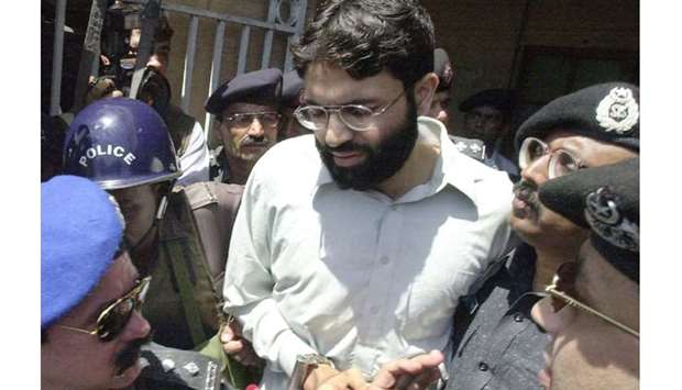 This picture taken on March 29, 2002, shows officers surrounding handcuffed Omar Sheikh as he left the courthouse in Karachi. The death sentence for British-born Sheikh has been overturned.