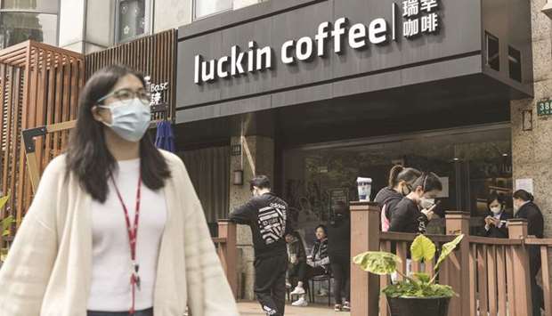 A pedestrian walks past a Luckin Coffee shop in Hong Kong. The companyu2019s shares plunged as much as 81% in US trading and CAR Inc, a rental company founded by Luckin Coffeeu2019s chairman, sank 54% in Hong Kong.