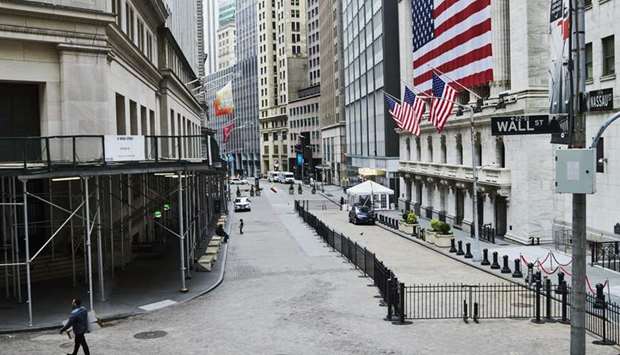 A pedestrian walks past the New York Stock Exchange on a nearly empty Wall Street. Investors are parsing a broad range of signals, from infection counts to more traditional  indicators, for clues on the trajectory markets may take in coming weeks as the pandemic caused by the novel coronavirus continues to spread.S