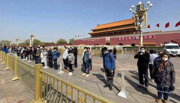 People bow in front of Tiananmen Gate in Beijing during a three minute national memorial to commemorate people who died in the COVID-19 coronavirus outbreak
