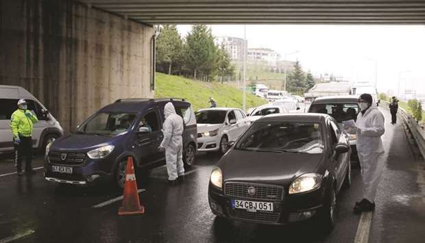 Turkish police officers check travel permits on a highway near Istanbul after the government decided to shut down the borders of  31 cities for all vehicles excluding transit passage for essential supplies, as the spread of coronavirus disease continues, at the outskirts of Istanbul yesterday. The coronavirus pandemic is expected to dramatically slow economic activity in Turkey and around the world, and could further ease inflation in the months ahead.
