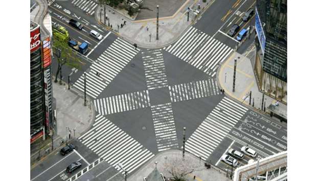 An aerial view shows less than usual passersby seen at a pedestrian crossing at Ginza shopping and amusement district in Tokyo, Japan.