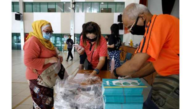 Residents receive free reusable masks distributed by the government at a community centre, as stricter measures are announced to combat the outbreak of the coronavirus disease (Covid-19) in Singapore, yesterday.