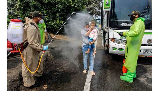 National Police members disinfect Venezuelan citizens returning to the country from Colombia, as a preventive measure against the spread of Covid-19, at the Simon Boliviar  International Bridge, in Cucuta, Colombia-Venezuela border.