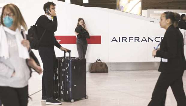 Travellers gather near the Air France-KLM ticket office at Charles de Gaulle Airport, operated by Aeroports de Paris, in Roissy, France.