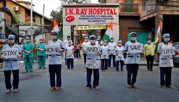 Medical staff hold placards as they stand outside a hospital to show solidarity with people who are affected by the coronavirus disease, and with doctors, nurses and other healthcare workers from all over the world, in Kolkata yesterday.