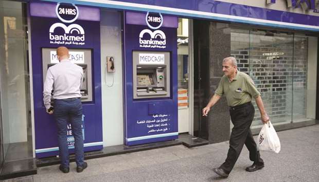 A man walks past a closed bank office in Beirut (file). The shortages of hard currency have already led to a deep recession and crippled many businesses as they struggle to import essential goods.