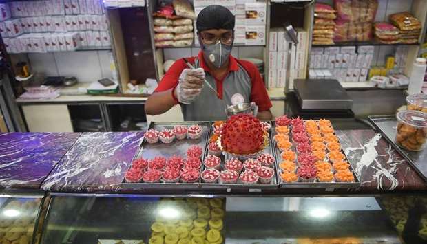 A worker gives the final touches to sweets featuring the novel coronavirus in a shop in Kolkata yesterday.