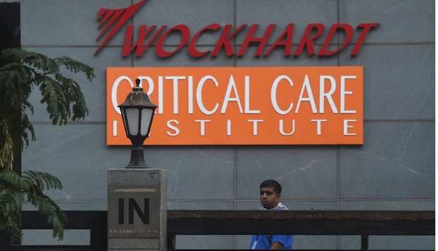 An employee stands in front of the entrance of the Wockhardt Hospital in Mumbai yesterday. The private hospital was shut to new patients and declared a coronavirus containment zone yesterday.
