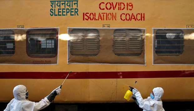 A worker wearing a protective suit disinfects the exterior of a passenger train after it was converted into an isolation facility on the outskirts of Kolkata yesterday.