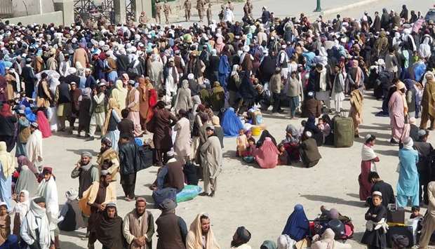 People gather as they wait to cross, after according to the media, Pakistan opens its border with Afghanistan that was closed in preventive measure following an outbreak of coronavirus disease (Covid -19), at the Friendship Gate crossing point at the Pakistan-Afghanistan border town of Chaman yesterday.