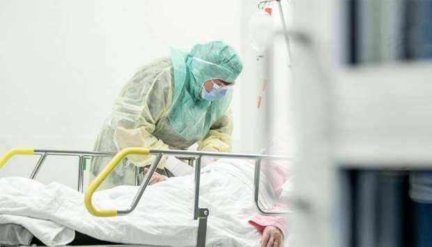 A nurse in protective clothes takes a blood sample of a patient potentially infected by the novel coronavirus Covid-19