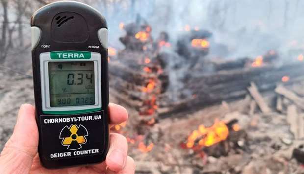 A geiger counter measures a radiation level at a site of fire burning in the exclusion zone around the Chernobyl nuclear power plant