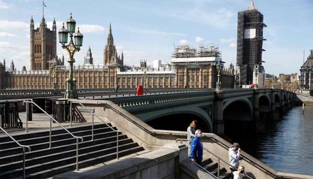 A general view of people wearing protective face mask's on steps by Westminster bridge as the spread of the coronavirus disease (COVID-19) continues, London
