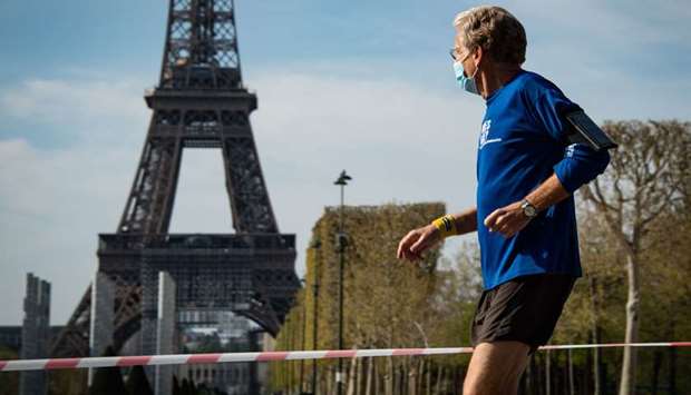 A man jogs near the Eiffel tower in Paris. The city authorities are banning daytime jogging from today.