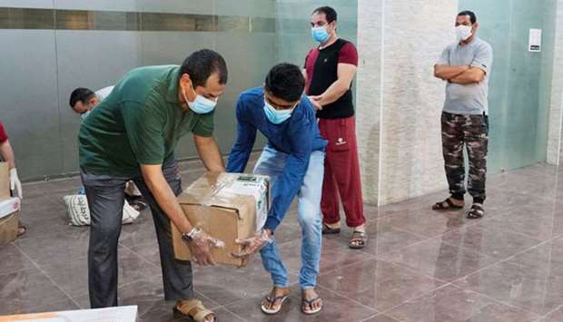 Expatriates in lockdown at a quarantined building, receive food from a Kuwaiti charity in Farwaniya.