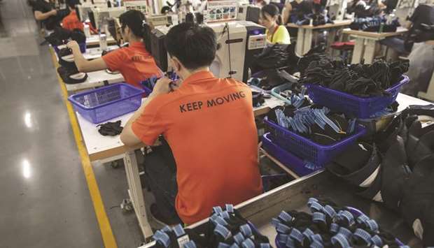 Workers operate sewing machines on the footwear production line at a sports goods factory in Jinjiang, Fujian. About 70mn-80mn people in services, manufacturing and construction sectors in China either lost jobs or werenu2019t working at the end of March because of shutdowns to contain coronavirus, economists at the UBS Group said.