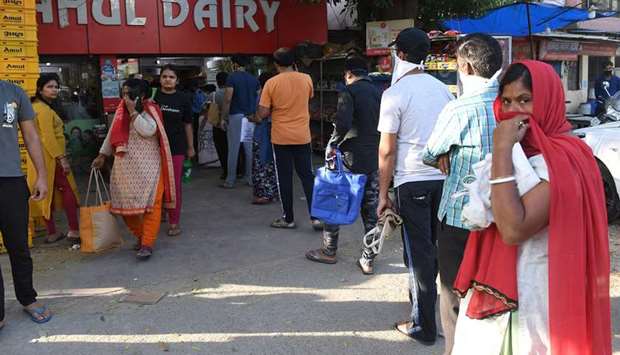 People wait outside a store to buy groceries following Uttar Pradesh governmentu2019s decision to seal hotspots in 15 coronavirus-hit districts, in Ghaziabad yesterday.
