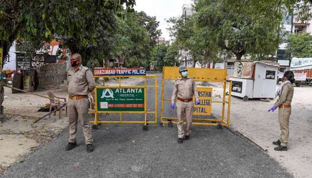 Police persoonel stand guard at the sealed entry-exit of sector-2B of Vasundhara following Uttar Pradesh government's decision to seal hotspots in 15 coronavirus-hit districts during a government-imposed nationwide lockdown as a preventive measure against the COVID-19 coronavirus, in Ghaziabad