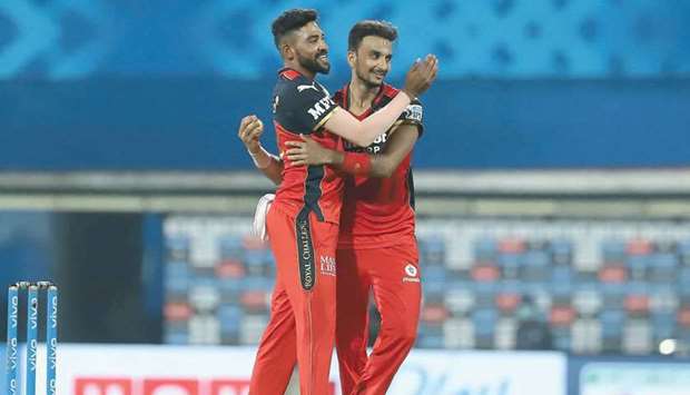Royal Challengers Bangaloreu2019s Harshal Patel (right) celebrates with Mohamed Siraj after taking the wicket of Kieron Pollard of Mumbai Indians during the Indian Premier League. b(Sportzpics for IPL)