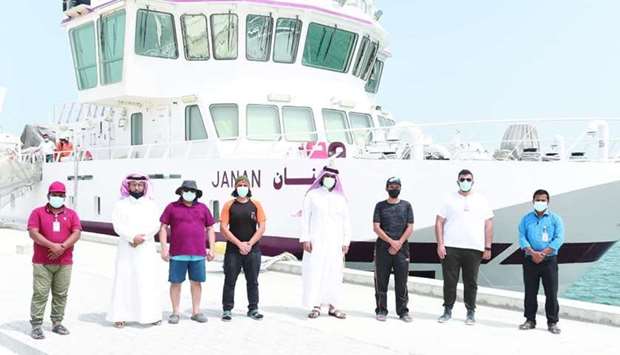 Some of the team members pose in front of the research vessel Janan.