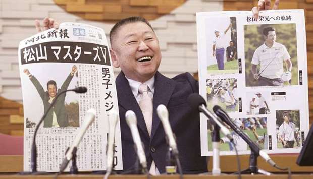 Yasuhiko Abe, who coached golfer Hideki Matsuyama during his Tohoku Fukushi University years, holds special editions of newspapers featuring Matsuyamau2019s Masters victory as he speaks at a press conference in Sendai, Japan, yesterday.