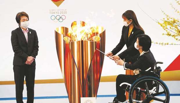 Tokyo 2020 President Seiko Hashimoto looks on as actor Satomi Ishihara and Paralympian Aki Taguchi light the celebration cauldron on the first day of the Tokyo 2020 Olympic torch relay in Naraha, Fukushima prefecture, on March 25.