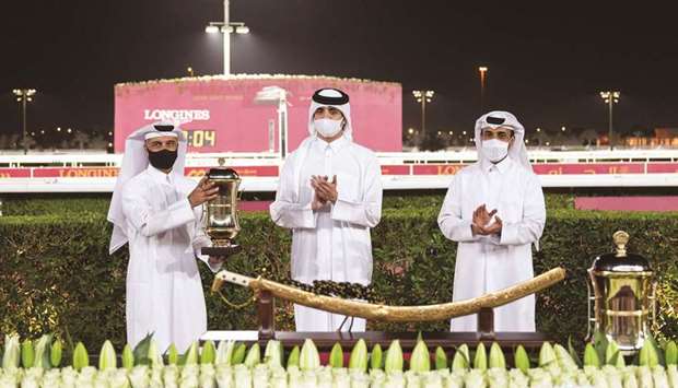 HE Sheikh Thani bin Hamad bin Khalifa al-Thani applauds as Hassan Ali al-Abdulmalik lifts the Qatar Gold Trophy after Seeyoubyme won the Thoroughbred feature on Thursday.