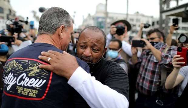 Najee Ali, a Black Lives Matter activist, embraces Peter Zazzara, a former Marine and White Lives Matter activist, after they agreed Derek Chauvin, the former Minneapolis police officer accused of murdering George Floyd, was guilty, during a confrontation, in Huntington Beach, California