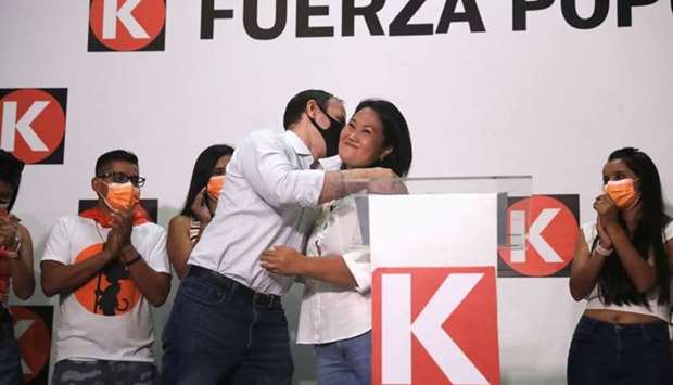 Peru's presidential candidate Keiko Fujimori of the Fuerza Popular party is embraced by her husband Mark Vito Villanella during a speech at party headquarters in Lima, Peru