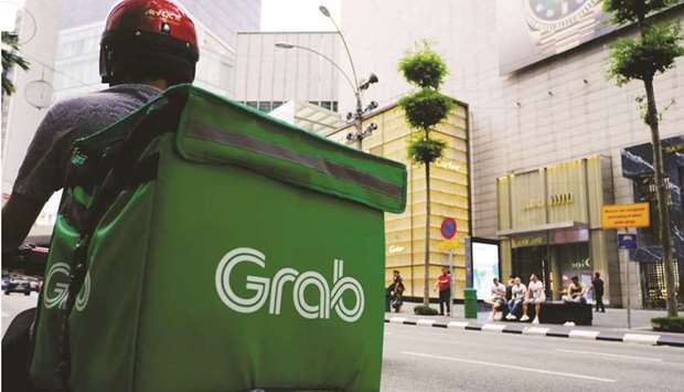 A Grab Holdings driver waits for an order in the Bukit Bintang district of Kuala Lumpur. Southeast Asiau2019s most valuable startup is going public in the US through the largest-ever merger with a blank-check company.