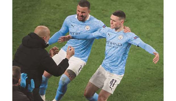 Manchester Cityu2019s Phil Foden (right) celebrates scoring a goal with teammate Kyle Walker (centre) and manager Pep Guardiola during the UEFA Champions League quarter-final second leg against Borussia Dortmund in Dortmund, Germany, yesterday. (Reuters)