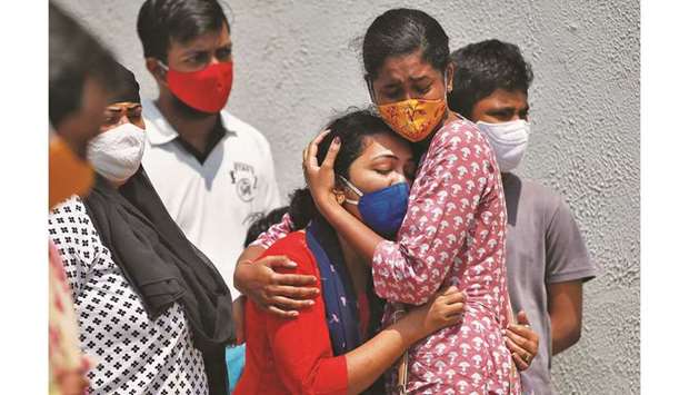 A woman whose husband died due to coronavirus is consoled outside a Covid-19 hospital mortuary in Ahmedabad, India, yesterday.