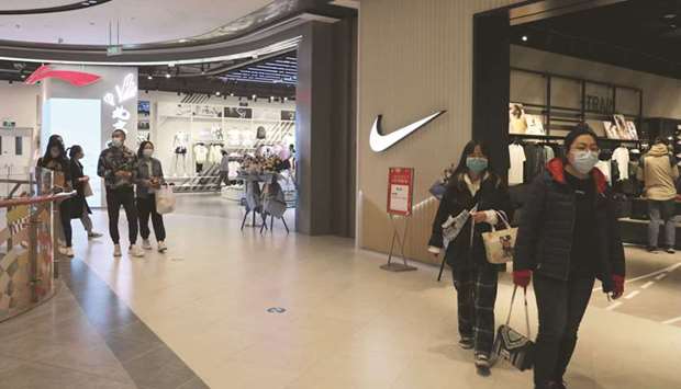 People walk past sportswear stores of Nike and Li-Ning at a newly-opened shopping mall in Beijing. Chinau2019s economy strengthened in the first quarter of the year as consumer spending rose more than expected, putting it on course to join the US as twin engines for a global recovery in 2021.