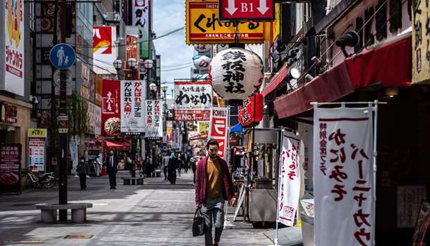 A man walks in the Dotonbori area of Osaka, Japan, as record numbers of new Covid-19 infections were reported in the city in recent days.