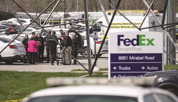 A group of crime scene investigators gather to speak in the parking lot of a FedEx SmartPost building in Indianapolis, Indiana.