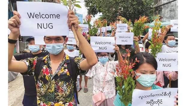 Anti-government protesters hold placards to show their support and welcome the new National Unity Government founded by ousted NLD legislators in Yangon, yesterday.