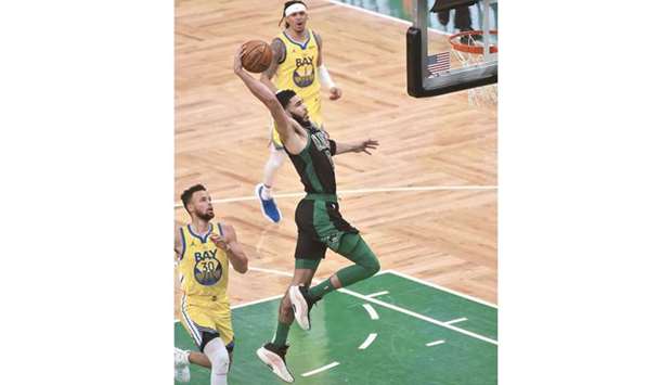 Boston Celtics forward Jayson Tatum goes in for a dunk past Golden State Warriors guard Stephen Curry (left) during the second half of their NBA game at TD Garden in Boston. (USA TODAY Sports)
